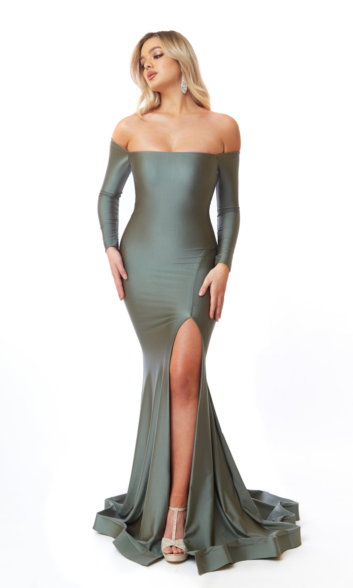 A person wearing the Atria 6554H Off-Shoulder Long Sleeve Prom Dress, featuring a thigh-high slit and floor-length hem, stands against a white background.